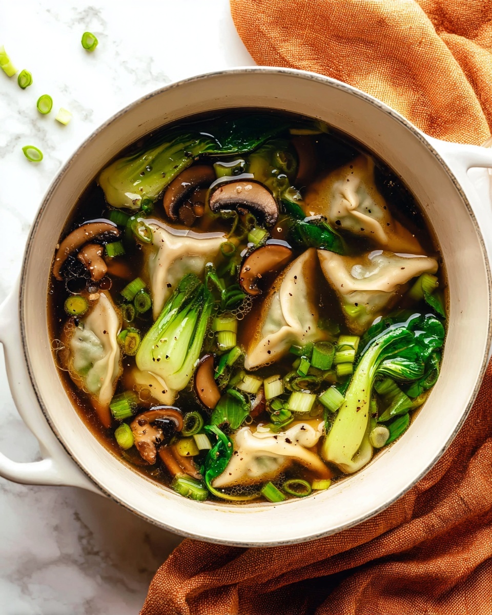 A white pot filled with dark brown broth holding several light beige dumplings floating on top. Bright green bok choy leaves and light green sliced scallions are scattered throughout the soup. Dark brown mushroom slices add texture, and a silver ladle is partly submerged in the broth with a bit of bok choy resting on it. The pot sits on a soft brown cloth on a white marbled surface. Photo taken with an iphone --ar 4:5 --v 7