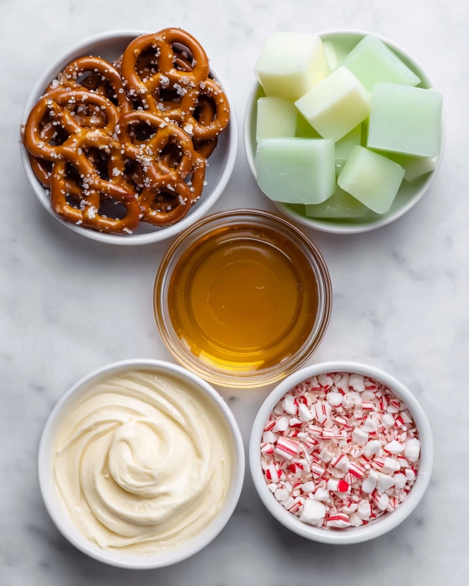 The image shows five small white bowls arranged on a white marbled surface. The top left bowl is filled with golden brown pretzels sprinkled with coarse salt, showing their twisted shape and crunchy texture. To the right is a bowl with light green translucent cubes of candy that have a glossy finish and look soft. Below the pretzels is a glass bowl holding amber-colored syrup with a smooth, shiny surface. Next to it, the bottom left bowl contains a creamy white substance with a soft, swirled texture. The last bowl, at the bottom right, holds small red and white peppermint candy pieces that look crisp and crushed. photo taken with an iphone --ar 4:5 --v 7