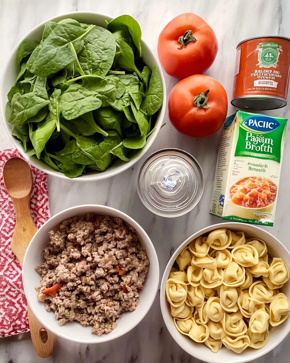 The image shows a white bowl filled with fresh green spinach leaves placed on a white marbled surface. Next to it are two cans of Italian style diced tomatoes standing upright side by side. There is a package of Philadelphia cream cheese and a wooden spoon with a red and white kitchen towel folded neatly beside it. A carton of Pacific organic vegetable broth lies flat, showing the front label. In the center, there is another white bowl filled with browned ground meat, and to the right, a white bowl holds uncooked tortellini pasta. Photo taken with an iphone --ar 4:5 --v 7