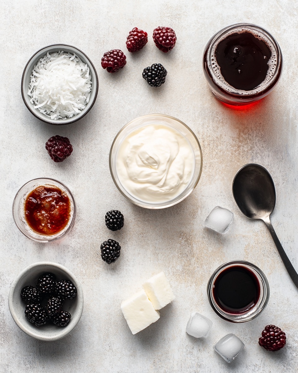 A tall clear glass filled with a dark brown drink and crushed ice that swirls with white cream or foam creating a marbled effect inside the glass; the top layer is a thick white foam sprinkled with light brown crushed nuts, and a green lime wedge is placed on the glass rim. The glass sits on a white marbled surface, with a blurred background showing a white bottle, two bright green limes (one whole and one sliced in half), a small white bowl with light brown liquid, and a tiny white bowl with crushed nuts scattered nearby. The glass is covered with small droplets of condensation. Photo taken with an iphone --ar 4:5 --v 7