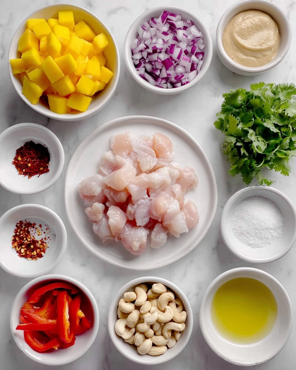 The image shows several small white bowls with different ingredients on a white marbled surface. In the center, a white plate holds many small, raw, pale pink chicken pieces. To the top left, a white bowl contains yellow, diced mango cubes. Around the chicken, starting from the top right and moving clockwise, there is a bowl of chopped red onion with a mix of purple and white colors, a bowl of fresh green cilantro leaves, a bowl filled with light-colored whole cashews, a bowl with red chili flakes, a bowl with white salt crystals, a bowl with sliced red bell pepper, and a bowl with a light yellow liquid that looks like oil. There is also a white bowl with a beige paste in the upper right corner. All bowls are small and white, placed on the clean white marbled background. photo taken with an iphone --ar 4:5 --v 7