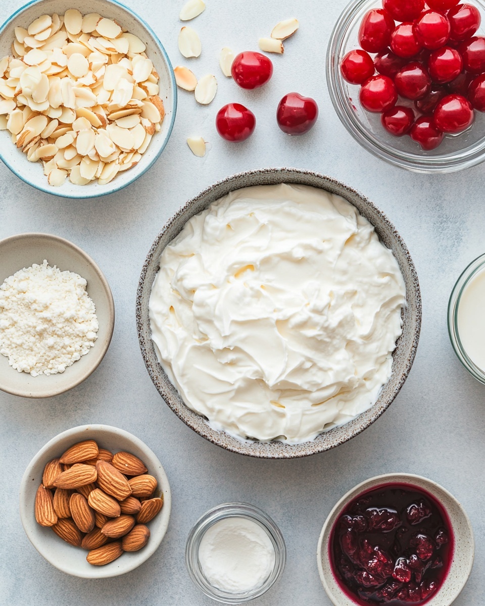 A white rectangular baking dish shows a layered dessert with three visible layers: a bottom layer of light yellow sponge cake, a middle layer of red strawberry filling with visible strawberry pieces, and a top thick layer of white whipped cream with red strawberry sauce swirled in, creating a marbled effect. The whipped cream layer is dotted with sliced almonds and a whole almond, adding texture. The dish is set on a white marbled surface with fresh strawberries and green leaves slightly blurred in the background. One section of the dessert is missing, revealing the cross-section of the layers. photo taken with an iphone --ar 4:5 --v 7
