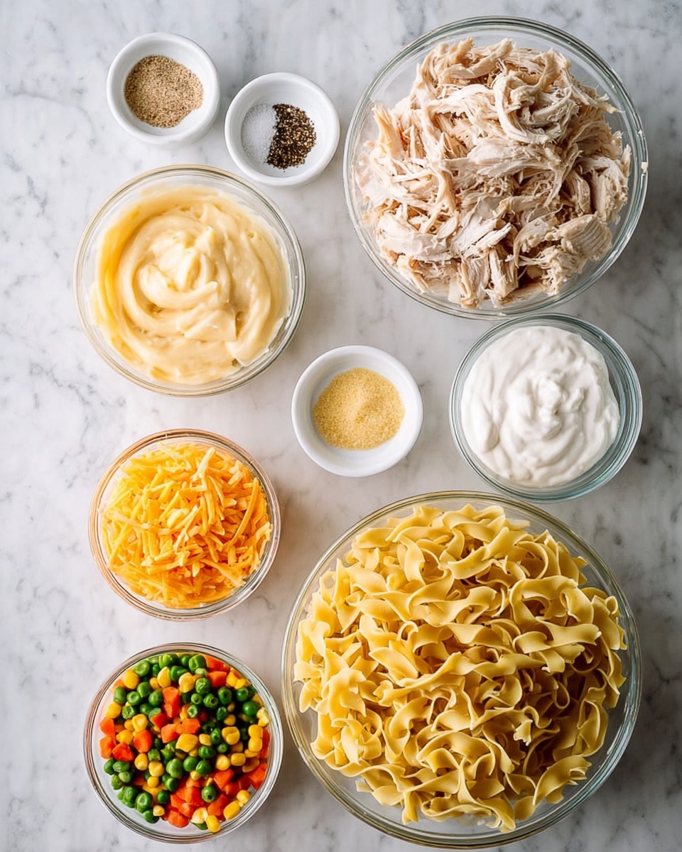 The image shows eight clear glass bowls placed on a white marbled surface, each containing different ingredients. The largest bowl in the bottom right is filled with uncooked yellow egg noodles, folded and twisted. Above it to the right is a medium bowl with shredded cooked chicken, light tan with some darker seasoning flecks. To the left of the chicken is a bowl of thick, creamy pale yellow cheese sauce. Below the sauce is a smaller bowl of shredded orange cheddar cheese. At the bottom left is a bowl with colorful frozen mixed vegetables—orange carrots, green beans, yellow corn, and green peas. Above the chicken and sauce are three small white bowls: one with ground black pepper, one with salt, and one with a light yellow powder (seasoning). To the upper right is a medium bowl of thick white cream. The photo taken with an iphone --ar 4:5 --v 7